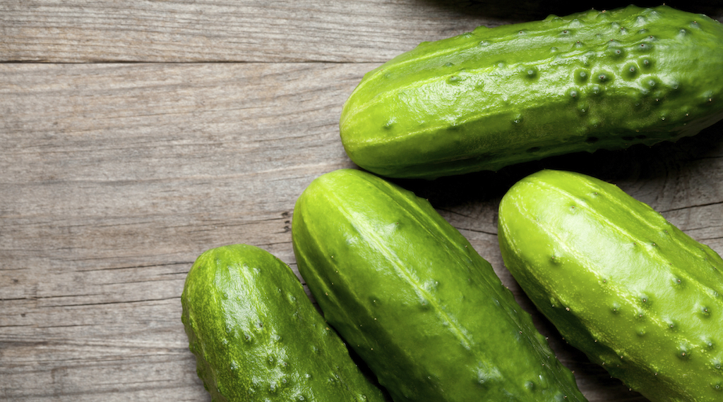 Natural cucumbers on old table. This file is cleaned and retouched.